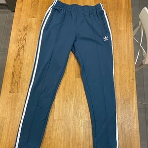 blue fitted track pants with zipper at ankle